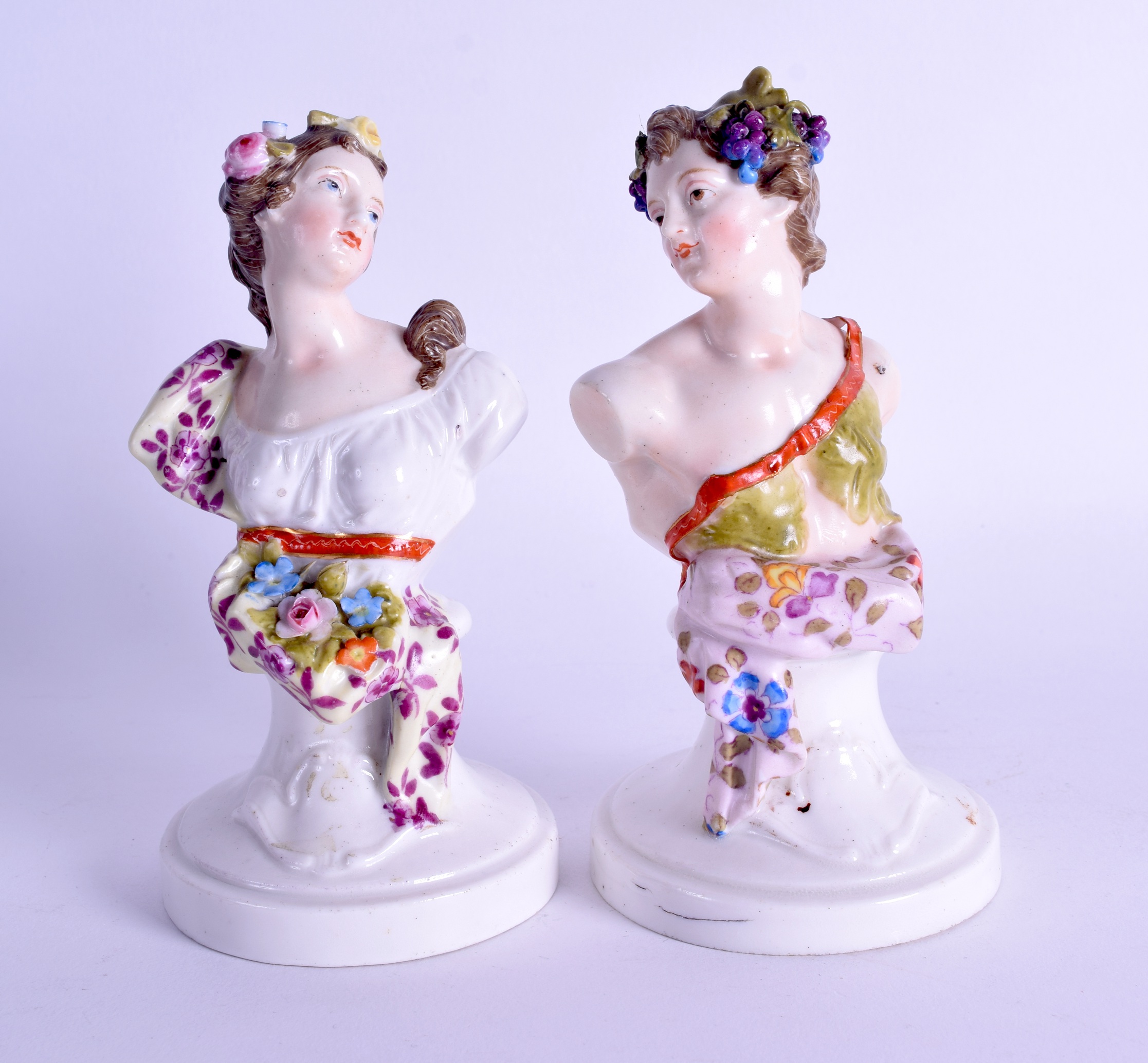 A PAIR OF 19TH CENTURY GERMAN PORCELAIN FIGURAL BUSTS painted with foliage and vines. 15 cm high.