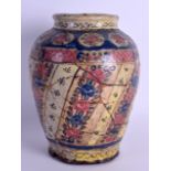 AN 18TH CENTURY PERSIAN TIN GLAZED POTTERY JAR painted with pink and blue flowers. 21 cm high.