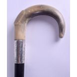 A VICTORIAN CARVED HORN HANDLED WALKING CANE possibly Rhinoceros, with engraved silver mounts. 93 cm