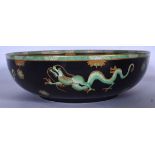 A LARGE CETEM WARE POTTERY BOWL, decorated with dragons in the Oriental taste. 31 cm wide.