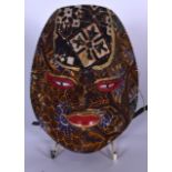 A BALINESE CARVED WOODEN BATIK CLOTH MASK, with painted red lips and eyes. 21 cm x 16.5 cm.