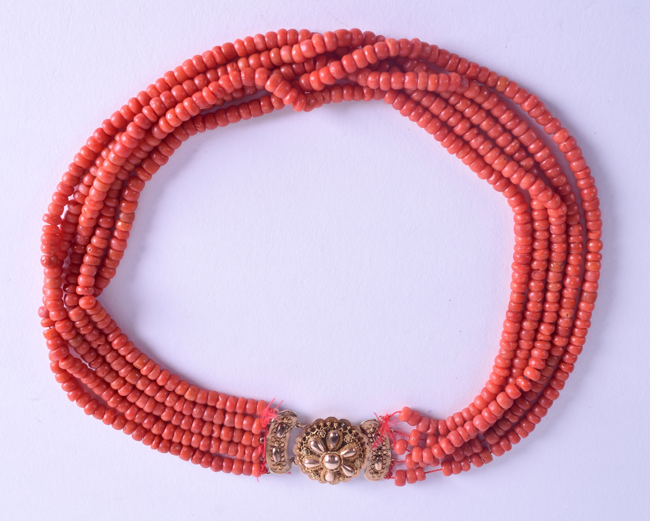 AN 18CT GOLD MOUNTED CORAL NECKLACE. 112 grams. Each strand 84 cm long, each bead 0.3 mm wide.