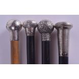 FOUR VICTORIAN/EDWARDIAN SILVER MOUNTED WALKING CANES three with ebonies shafts. 90 cm long. (4)