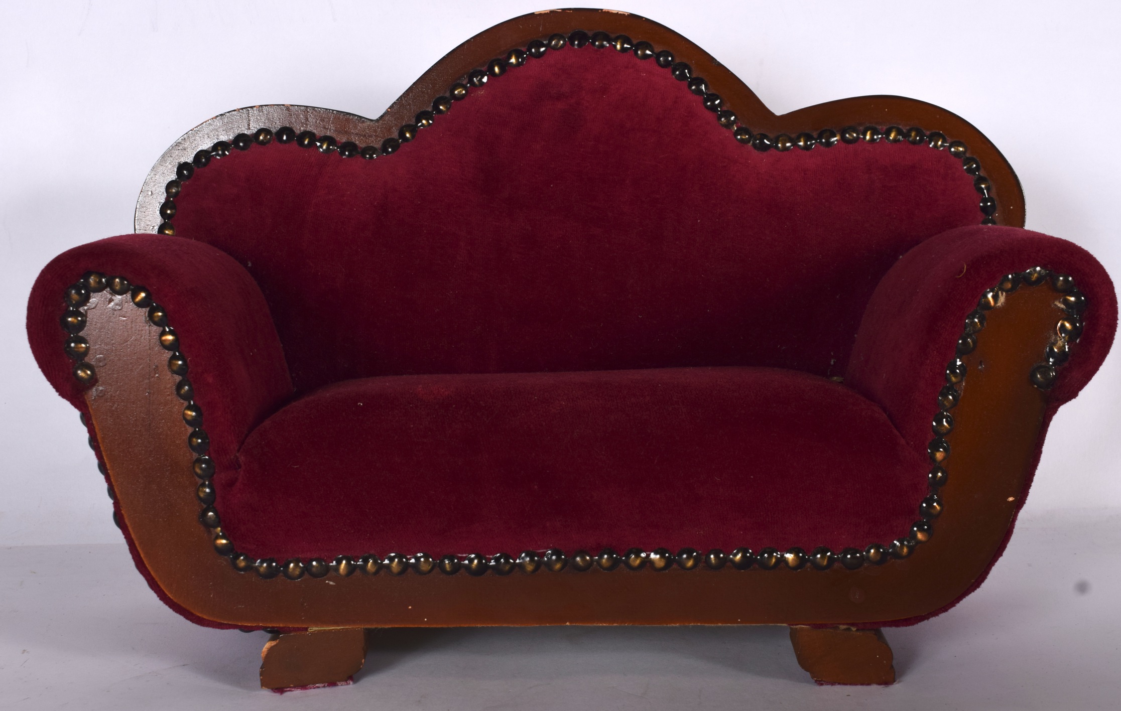 AN APPRENTICE SETTEE, with crimson upholstery and metal studwork. 42 cm wide