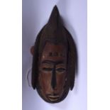 A 20TH CENTURY WOODEN TRIBAL WALL MASK, carved with an elongated face. 46 cm long.