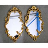 A PAIR OF EARLY 20TH CENTURY BRONZE MIRRORS, formed with scrolling floral decoration. 46 cm x 25