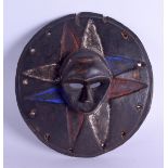 AN UNUSUAL EARLY 20TH CENTURY AFRICAN TRIBAL POLYCHROMED SHIELD decorated in relief with a maskhead.