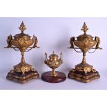 A 19TH CENTURY FRENCH GILT METAL MANTEL GARNITURE formed with two griffin mounts urns & a smaller