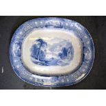 A 19TH CENTURY ENGLISH BLUE AND WHITE POTTERY PLATTER, decorated with figures boating in a