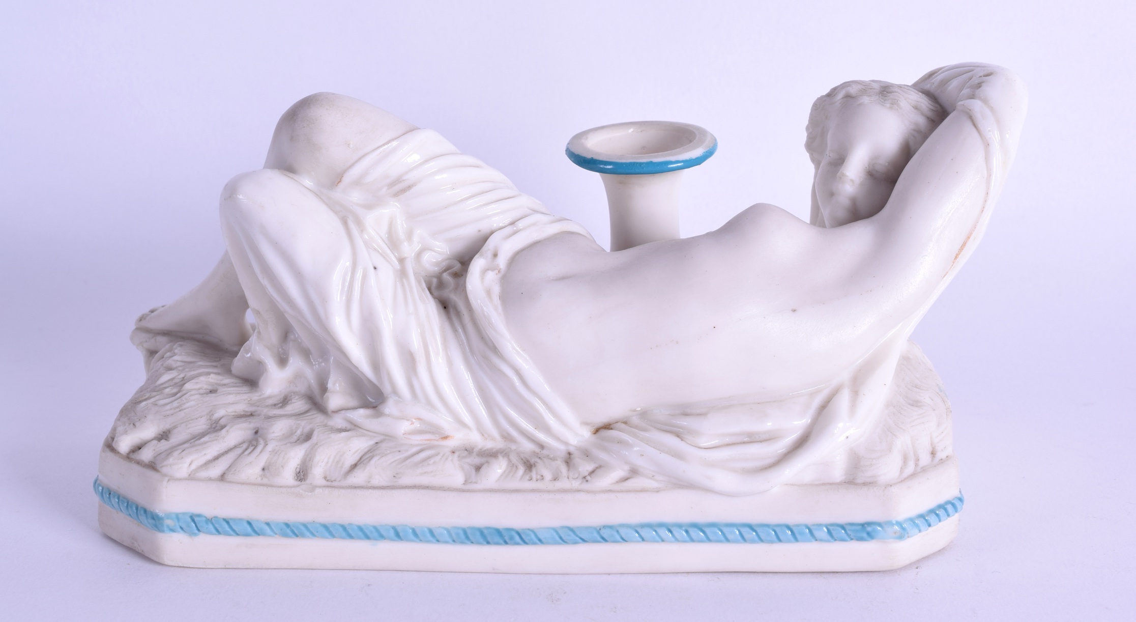 A 19TH CENTURY PARIANWARE FIGURE OF A SLEEPING FEMALE modelled reclining upon an octagonal base.