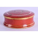 A SEVRES STYLE CORAL GROUND BOX AND COVER painted with motifs. 6 cm diameter.