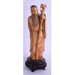 A 19TH CENTURY CHINESE CARVED AND STAINED IVORY IMMORTAL modelled holding a staff. Ivory 20 cm