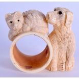 A CARVED BONE DOG AND CAT NAPKIN RING. 7 cm wide.