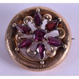 A 19TH CENTURY GOLD MOUNTED GARNET BROOCH with unusual two colour red and purple tones. 3.5 cm