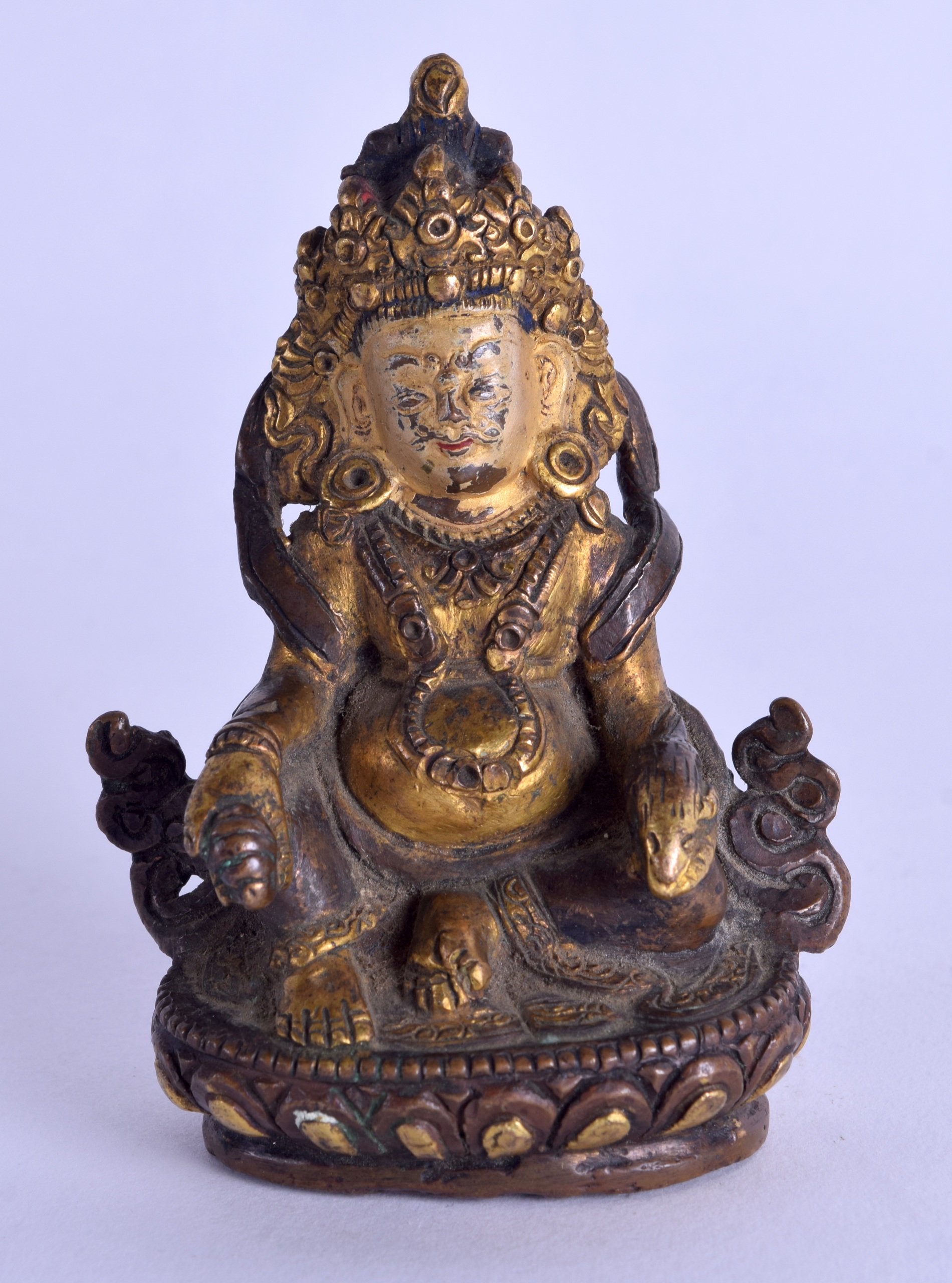 A LATE 19TH CENTURY CHINESE TIBETAN PAINTED BRONZE FIGURE OF A GOD modelled seated upon a lotus