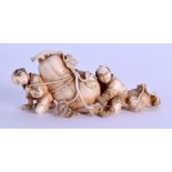 A 19TH CENTURY JAPANESE MEIJI PERIOD CARVED IVORY OKIMONO modelled as two boys pulling aloft a