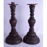 A LARGE PAIR OF 19TH CENTURY CONTINENTAL OAK CANDLESTICKS decorated with flowers. 42 cm high.