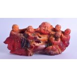 A CHINESE CARVED RECONSTITUED AMBER TYPE FIGURE OF A BUDDHA modelled with numerous children upon