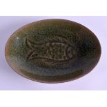 AN EARLY 20TH CENTURY CHINESE GREEN CELADON TYPE DISH decorated with a fish. 15 cm x 10 cm.