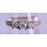 A 14CT GOLD THREE STONE DIAMOND RING of approx 0.5 cts. Size R/S.
