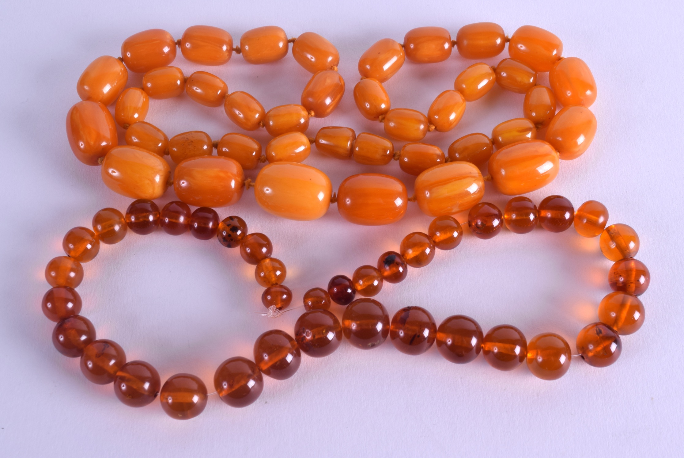 TWO AMBER TYPE NECKLACES. 155 grams. (2)