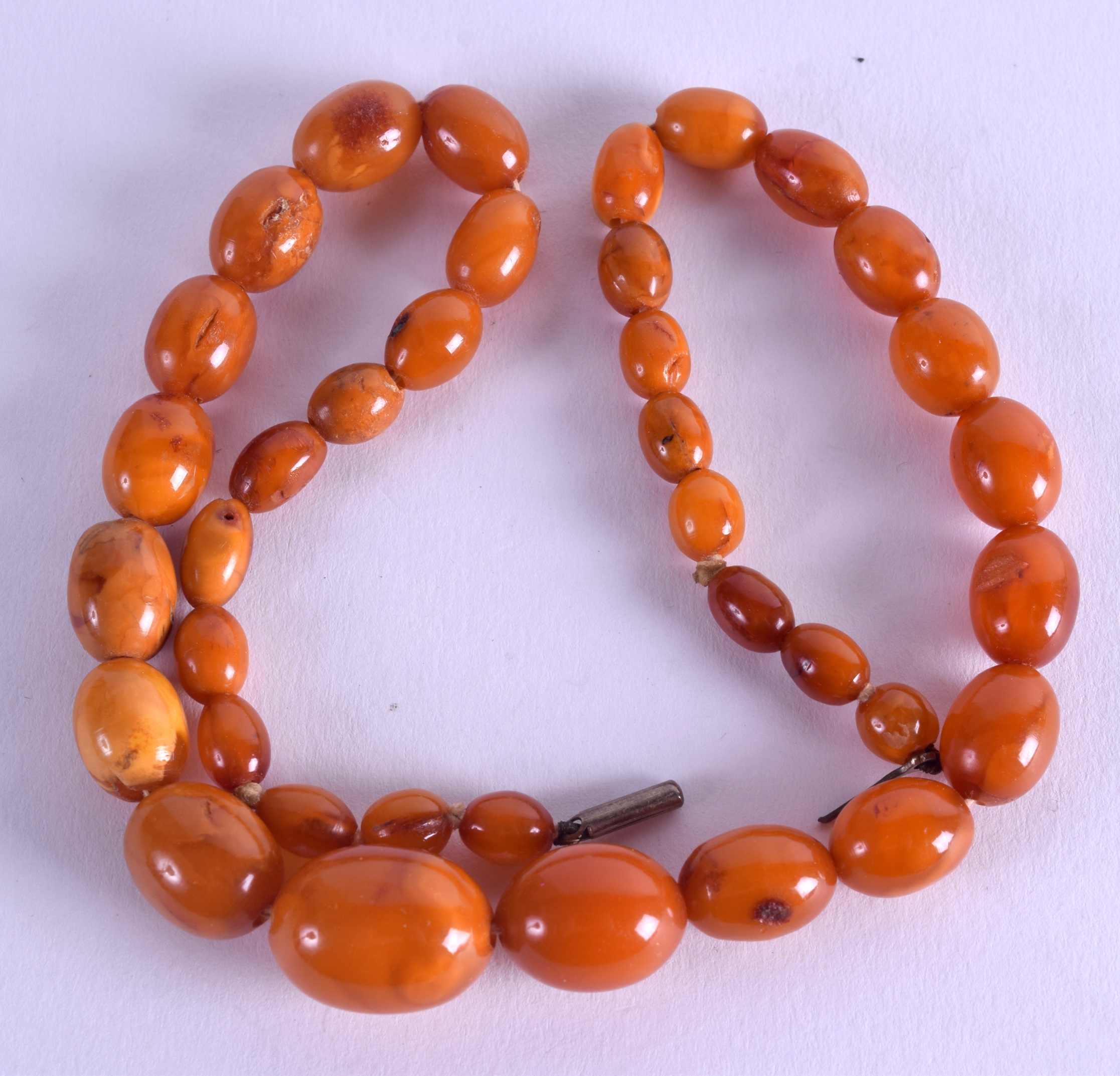 AN AMBER NECKLACE. 20 grams. 42 cm long, largest bead 1.75 cm wide.