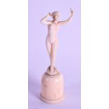 A MINIATURE 19TH CENTURY FRENCH CARVED IVORY FIGURE OF A NUDE FEMALE modelled with one hand raised.
