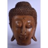 A 20TH CENTURY WOODEN THAI BUDDHA BUST, carved with elongated ear lobes. 26 cm high.