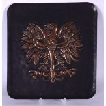 AN EARLY 20TH CENTURY COPPER PLAQUE, decorated in relief with a central eagle. 30 cm x 27.5 cm.