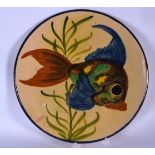A LARGE YELLOW GROUND CIRCULAR POTTERY DISH OR PLAQUE, painted wit a swimming fish. 32.5 cm.
