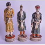 A SET OF THREE 18TH CENTURY INDIAN POLYCHROMED IVORY FIGURES modelled upon circular bases. Largest 1