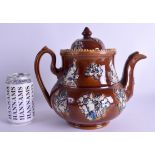 A LARGE 19TH CENTURY TREACLE GLAZED BARGEWARE TEAPOT AND COVER decorated with animals and floral spr