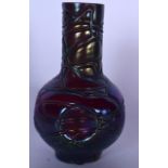 AN IRIDESCENT GLASS VASE ATTRIBUTED TO TIFFANY, formed with a purple swirling body. 17 cm high.