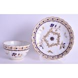 AN 18TH CENTURY WORCESTER TEABOWL AND SAUCER of fluted form, painted with blue and gilded flowers. (