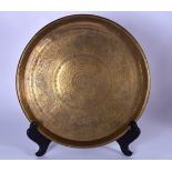 A LARGE 19TH CENTURY EASTERN BRASS DISH OR CHARGER, engraved with figures and animals in various pur