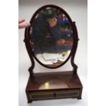 AN EDWARDIAN WOODEN TABLE MIRROR, formed with curving supports. 57 cm high.