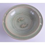 A CHINESE QING DYNASTY CELADON CIRCULAR POTTERY BOWL decorated with two fish in opposing stances. 27