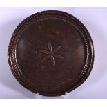 AN ARTS & CRAFTS COPPER DISH, decorated in relief with a stylised flower and hammered border. 23 cm