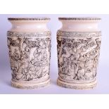 A FINE PAIR OF 19TH CENTURY JAPANESE MEIJI PERIOD CARVED IVORY VASES decorated with figures within l