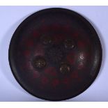 AN EARLY 20TH CENTURY PERSIAN OR ISLAMIC BRONZE SHIELD, decorated with red panels of foliage and rai