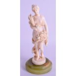 A 19TH CENTURY EUROPEAN CARVED IVORY FIGURE OF A FEMALE modelled holding a floral sprig. 17 cm high.