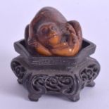 A 19TH CENTURY JAPANESE MEIJI PERIOD CARVED TAG OKIMONO modelled as a monkey grappling with a toad.