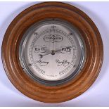 A MID 20TH CENTURY WOODEN WALL BAROMETER, circular in shape. 31 cm wide.