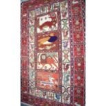 AN UNUSUAL RED GROUND RUG, decorated with panels of animals. 190 cm x 117 cm.