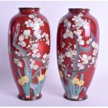A PAIR EARLY 20TH CENTURY JAPANESE MEIJI PERIOD CLOISONNE ENAMEL VASES decorated with trees on a red