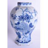 AN 18TH CENTURY CONTINENTAL DELFT BLUE AND WHITE FAIENCE VASE painted with flowers and hollow rock.