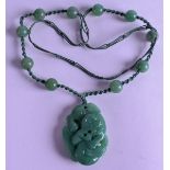 AN EARLY 20TH CENTURY CHINESE CARVED JADE NECKLACE Late Qing/Republic. Pendant 3.5 cm x 4.5 cm.