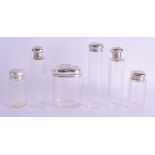 SIX EDWARDIAN SILVER TOPPED DRESSING TABLE JARS. Birmingham 1910. Largest 13 cm high. (6)