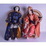 A LARGE PAIR OF 1950S CHINESE PORCELAIN HEADED DOLLS modelled seated upon wicker chairs. 48 cm high.