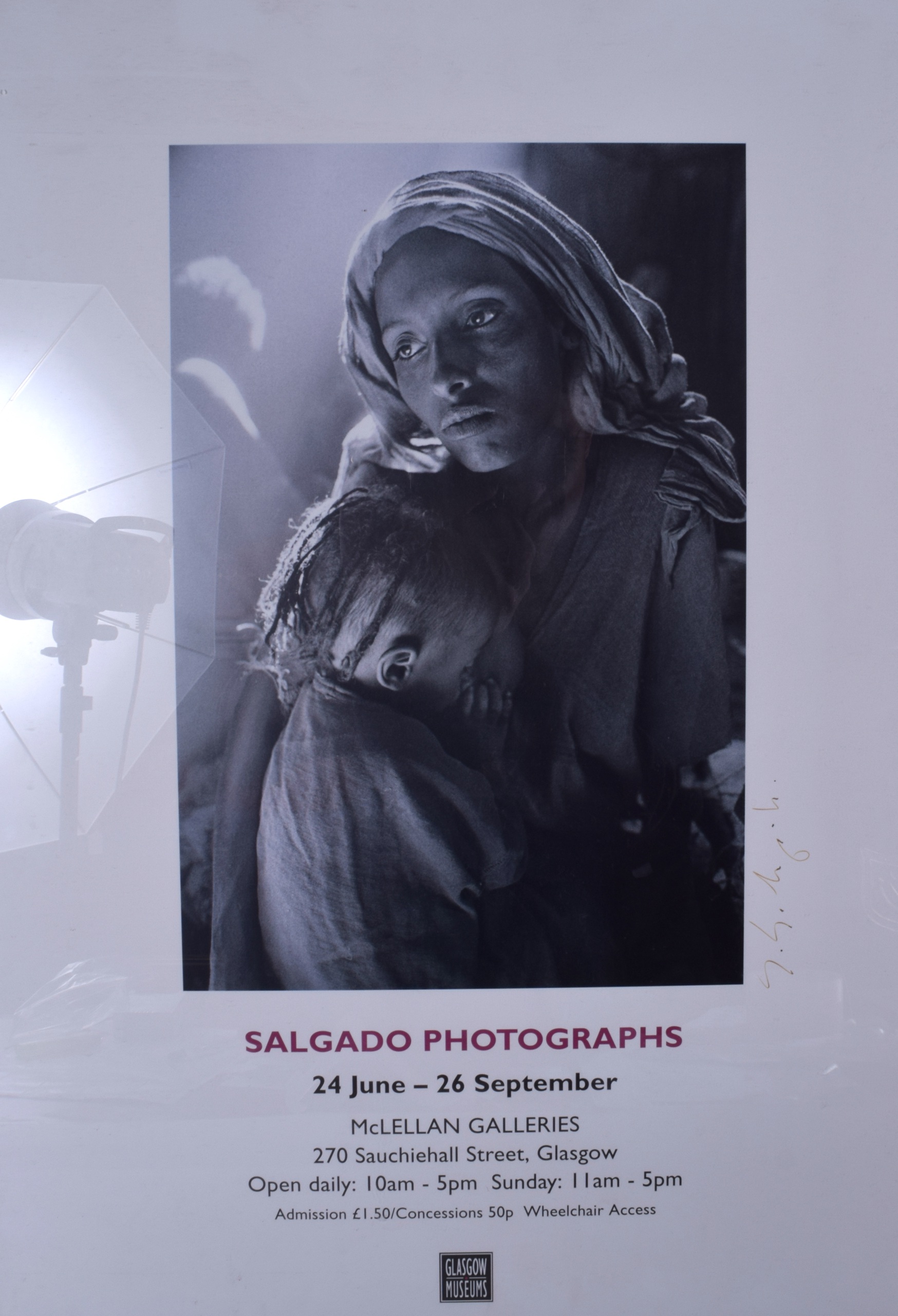 A FRAMED SALGADO PHOTOGRAPHS POSTER, signed. 58 cm x 41 cm.